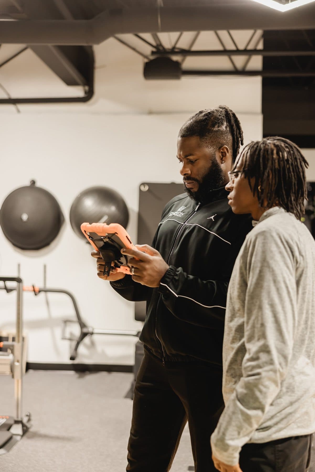 A Chiron coach reviewing test results on a tablet with an athlete