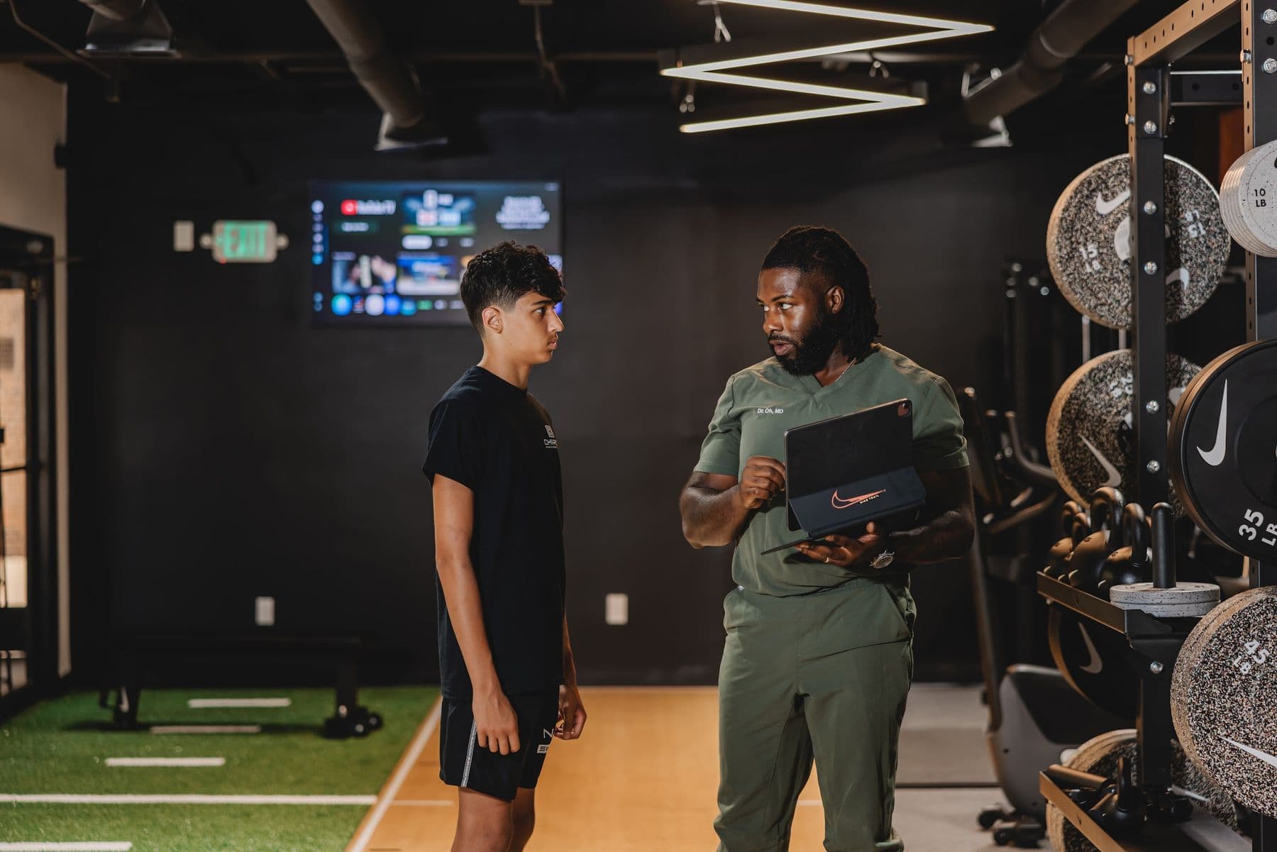 A Chiron coach reviewing results on a tablet with a young athlete