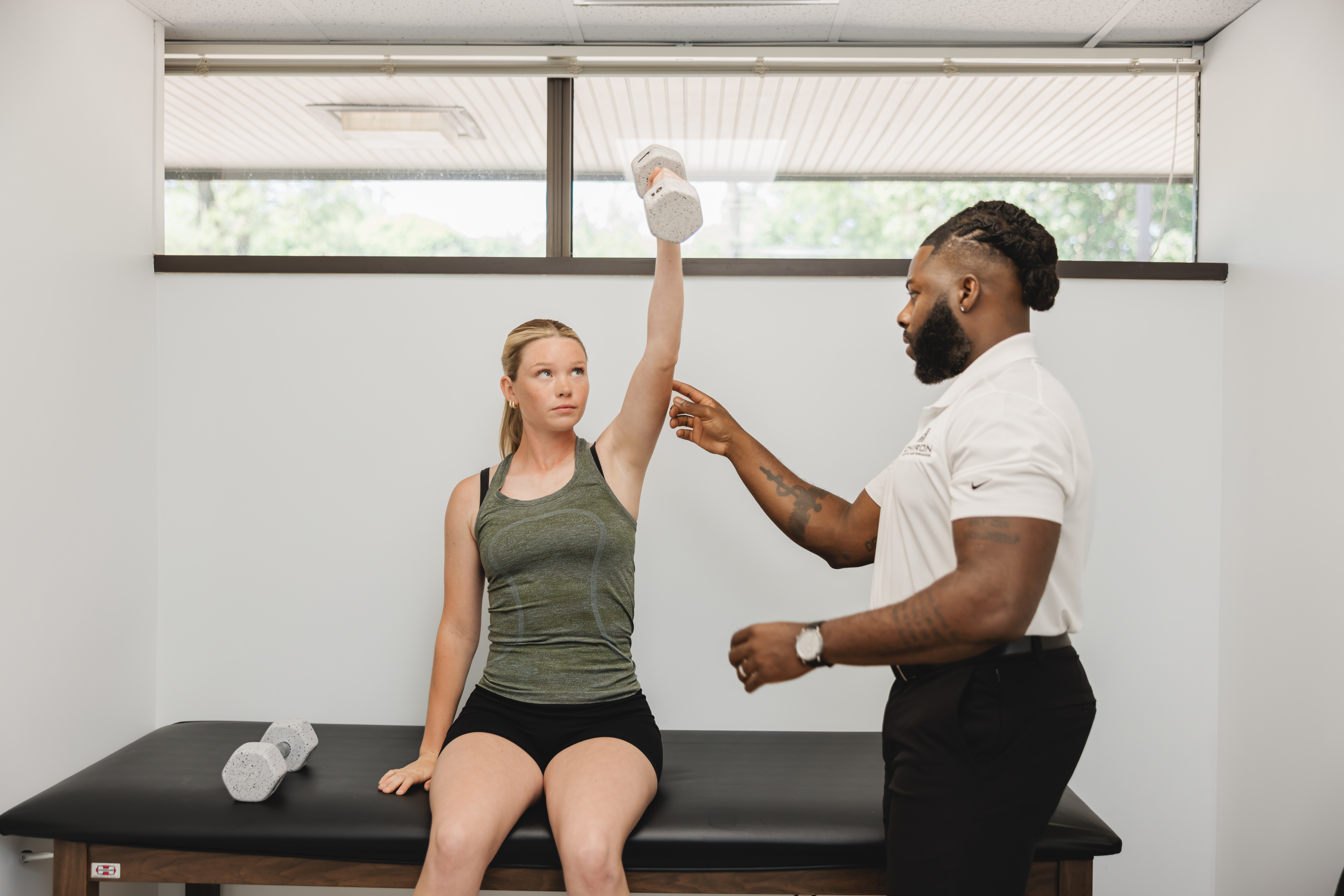 Dr. Ohanaja coaching athlete through shoulder strength assessment